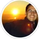 A man's profile photo with a sunset