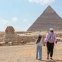 woman and her young child standing in front of the Great Pyramids of Egypt and the Sphinx